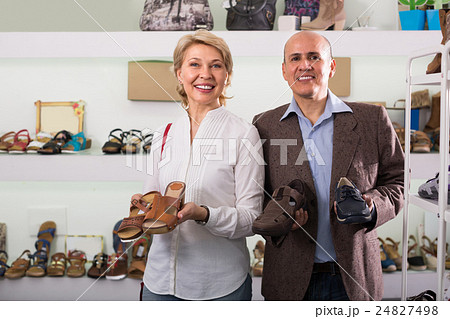 Mature couple picking shoes in boutique. 24827498