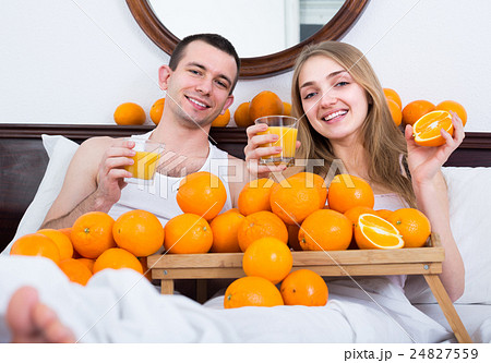 Couple with orange juice in bed. Couple with orange juice in bed. 24827559