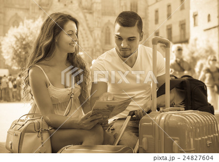 Couple with luggage reading map 24827604
