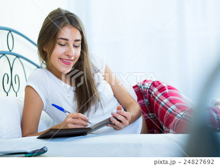 Portrait of girl putting dreams in notepad 24827692