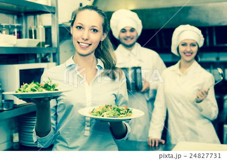 Chefs and waitress at kitchen 24827731