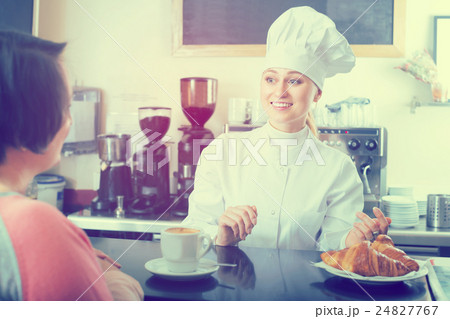 Cook selling pastry to customer Cook selling pastry to customer 24827767