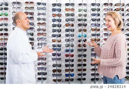 Male optician consulting mature female customer 24828314