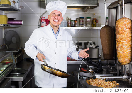 Mature man cook wearing uniform standing on kitchen Mature man cook wearing uniform standing on kitchen 24828460