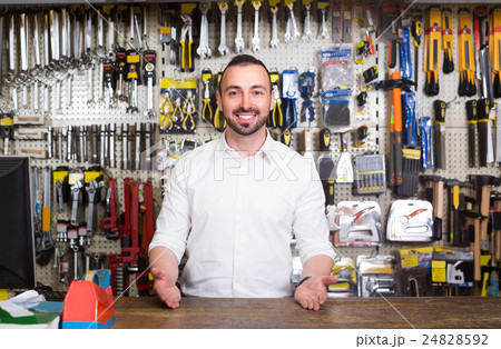 portrait of cheerful man at the cash desk working in tool-ware shop portrait of cheerful man at the cash desk working in tool-ware shop 24828592