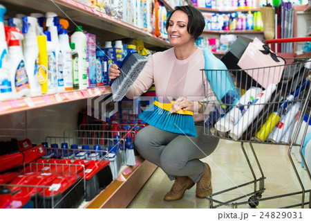 Adult woman choosing cleaning brush Adult woman choosing cleaning brush 24829031