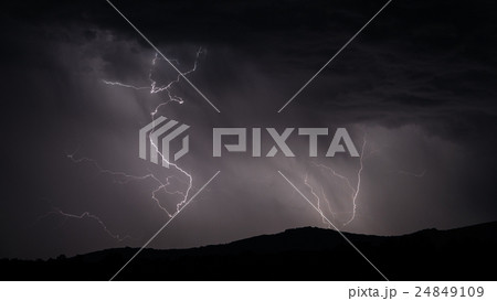 Lightning strike over mountain range with clouds Lightning strike over mountain range with clouds 24849109