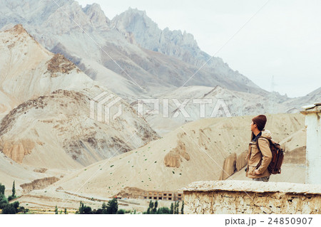 Young male traveler standing on cliff, thinking 24850907