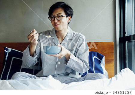 ベッドで朝食を食べる男性 24851257