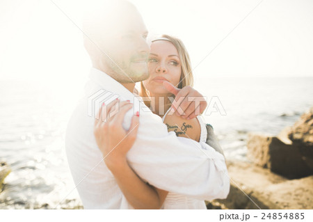 Wedding couple kissing and hugging on rocks near 24854885