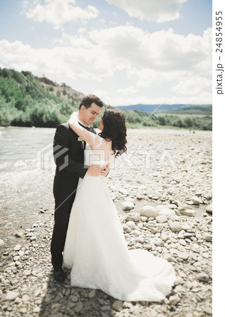 Elegant gentle stylish groom and bride near river 24854955