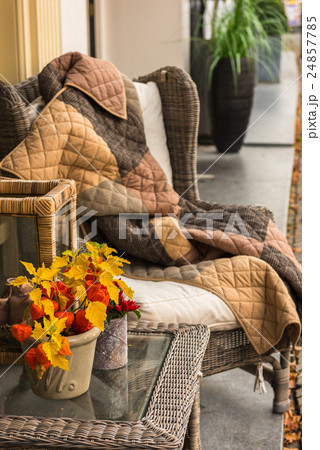 Cozy armchair with blanket and wicker glass table 24857785