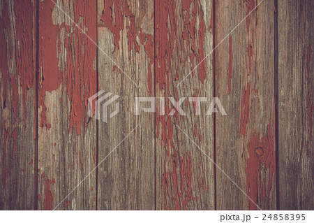 Red paint pealing off wooden planks 24858395