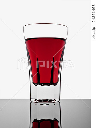 Glass with red drink on white background 24861468