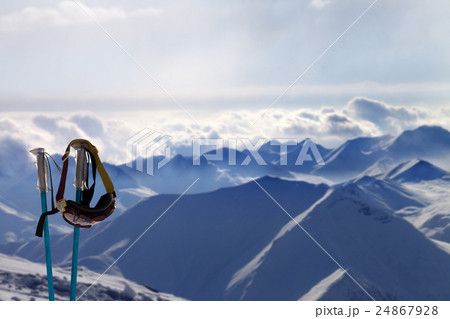Ski mask on ski poles in evening mountains Ski mask on ski poles in evening mountains 24867928