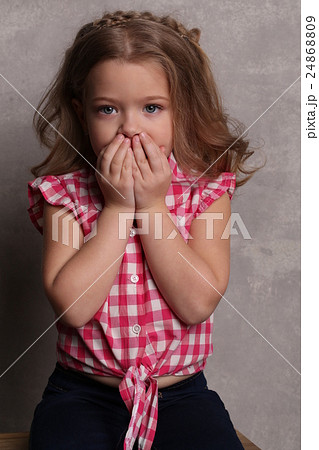 Little girl closing her mouth with hands. Close up 24868809