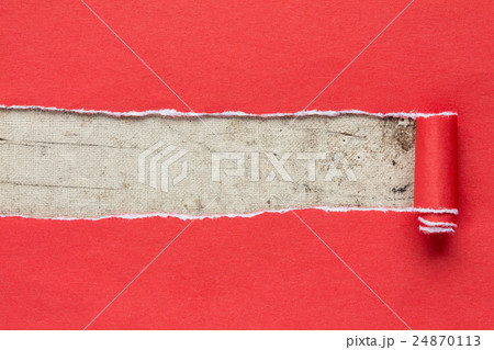 Torn red paper on dirty canvas. 24870113