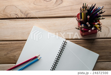 Color pencil and sketchbook on wood table 24872500