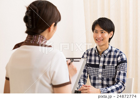 アロママッサージのカウンセリングを受ける男性とエステティシャン 24872774