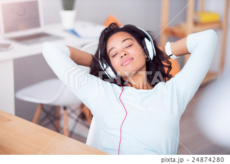 Pleasant relaxed woman listening to music Pleasant relaxed woman listening to music 24874280