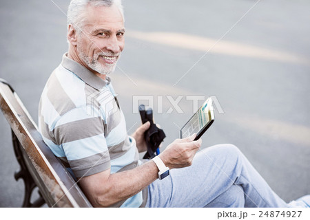 Sporty old man reading after the work-out in the 24874927