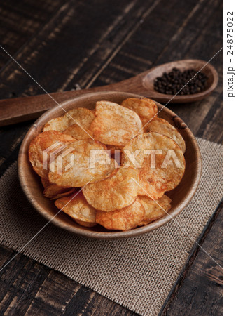 Bowl with potato crisps chips with pepper on wood Bowl with potato crisps chips with pepper on wood 24875022
