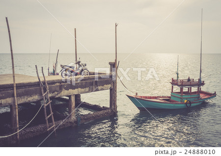 motorcycle and local fisher boat at pier. motorcycle and local fisher boat at pier. 24888010