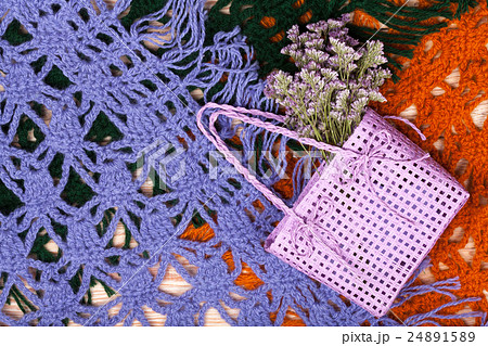 Knitted woolen female shawls on wooden background 24891589