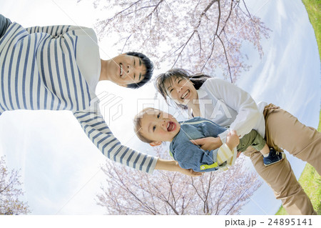 桜の咲く公園で遊ぶ3人家族 24895141