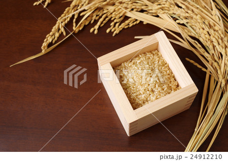 ヒノキの枡に盛られた玄米と稲穂 24912210
