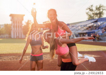 Group fit women giving piggyback ride Happy young 24912653