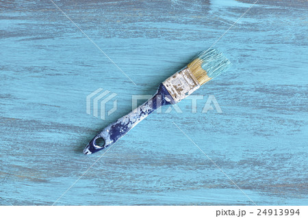 Paintbrush with blue paint on a wooden board. Paintbrush with blue paint on a wooden board. 24913994