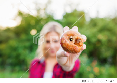 Unrecognizable blond woman holding rotten apple in 24914307