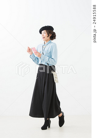 ベレー帽の女性（白背景　全身　携帯電話） 24915588