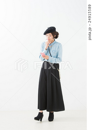 ベレー帽の女性（白背景　全身　携帯電話） 24915589