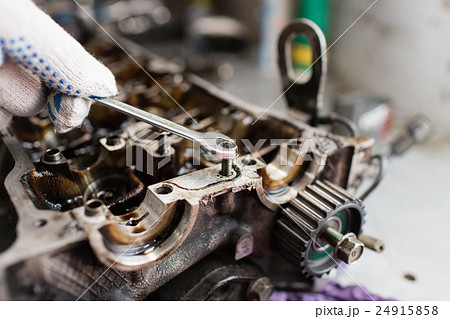 Mechanic hands tighten nut with wrench while 24915858