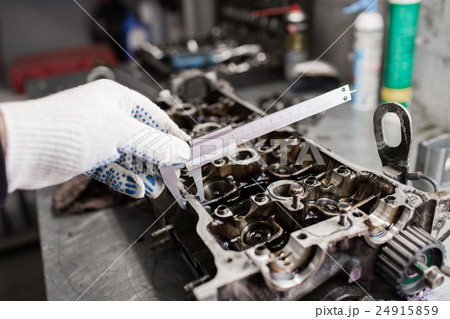Mechanic, using a calipher, to check the thickness 24915859