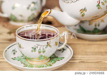 Pour tea into a cup. Vintage kitchen utensils 24934066