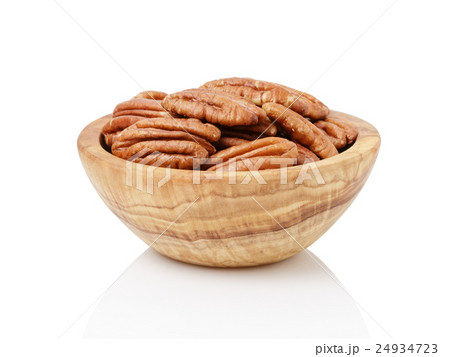 Pecan halves in a bowl isolated on a white 24934723