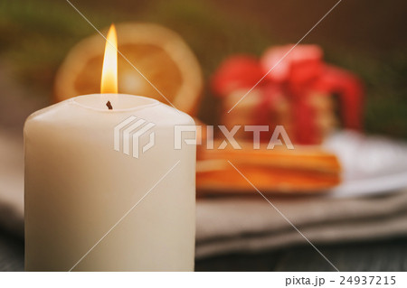 burning candle in front of christmas table,  24937215