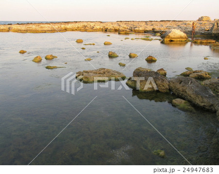 Sunset on a stony beach 24947683