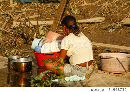 Woman washing dishes on the banks of the river 24948732