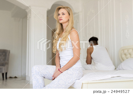 Young Couple Sitting Separate On Bed, Having 24949527