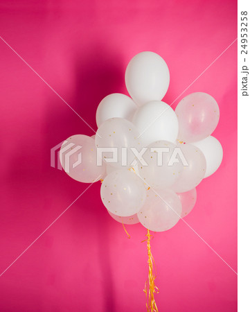 close up of white helium balloons over pink 24953258