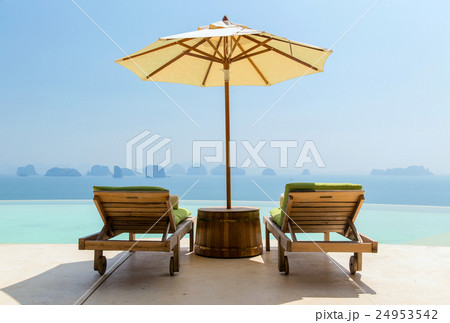 infinity pool with parasol and sun beds at seaside 24953542