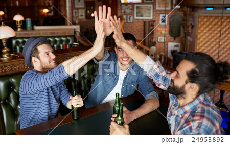men with beer making high five at bar or pub 24953892
