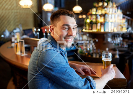 happy man drinking draft beer at bar or pub 24954071