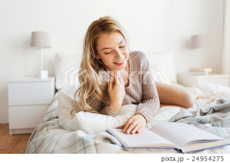 young woman reading book in bed at home young woman reading book in bed at home 24954275