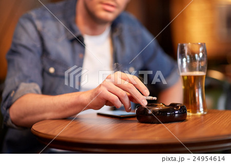 man drinking beer and smoking cigarette at bar man drinking beer and smoking cigarette at bar 24954614