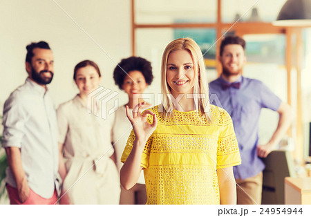 happy woman showing ok over creative office team happy woman showing ok over creative office team 24954944
